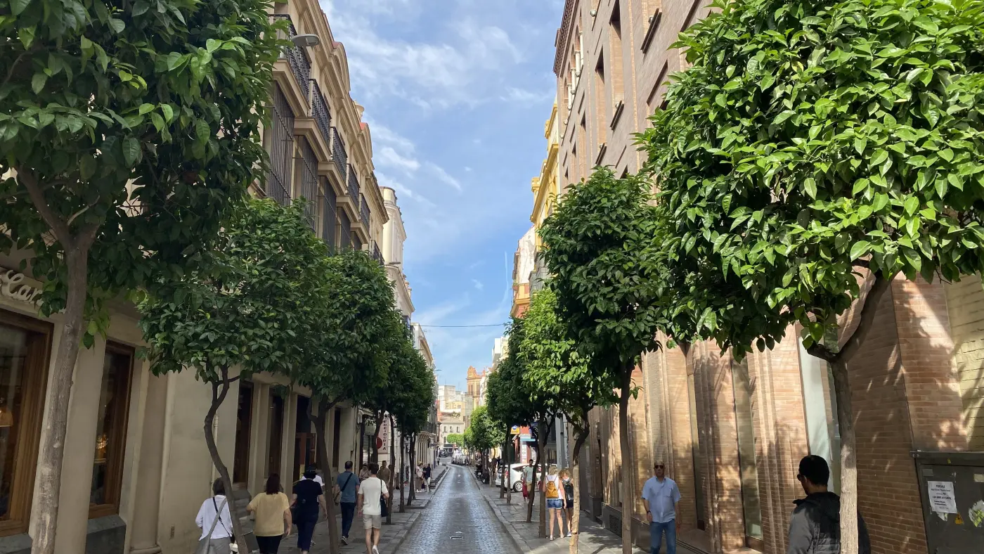 Escena urbana de Sevilla con fachada singular y vida de calle