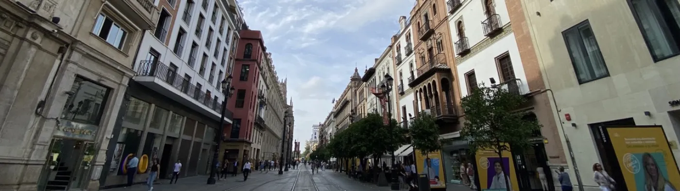 Perspectiva urbana de Sevilla con calle central y edificios singulares